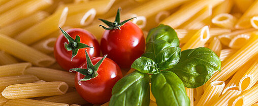 Die Nudeln sind mit Tomaten und Salat verziert.