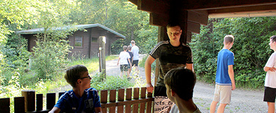 Nach einem anstrengenden Tag im Freizeitpark chillen die Jungs draußen vor den Blockhäusern im Camp.