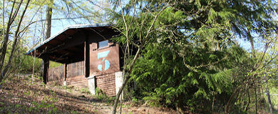 In der Sonne strahlt das Blockhaus "Blaue 3" mitten in den Sauerländer Bergen.