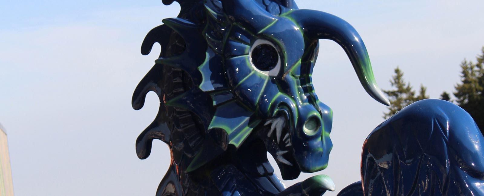 Der Kopf von dem Karussell Blauer Drache zeigt sich an der Spitze des Fahrgeschäfts.