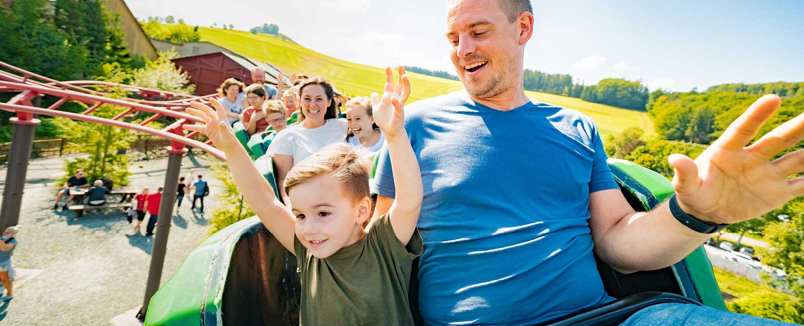 Vater und Sohn rasen mit der Achterbahn.