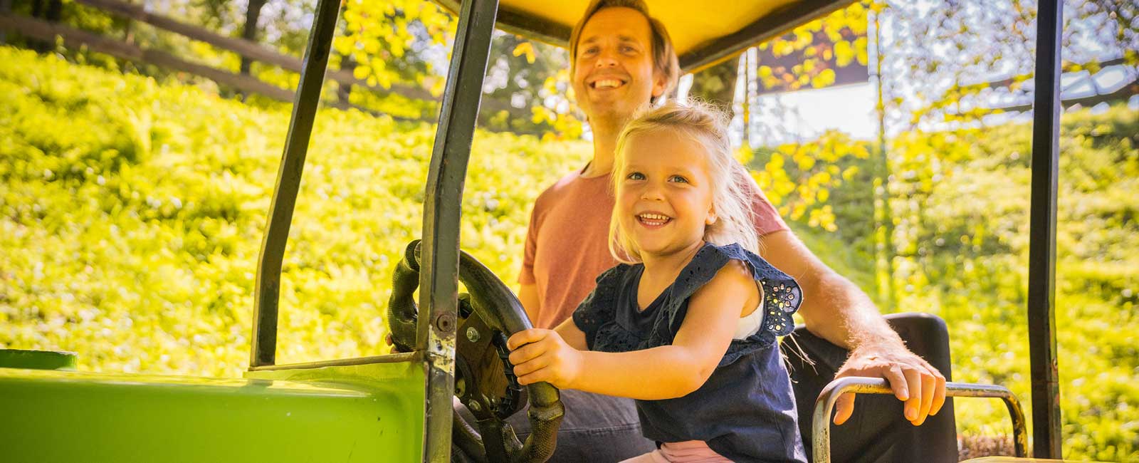 In Old McDonald's Traktor lächeln die Tochter mit ihrem Papa in die Kamera.