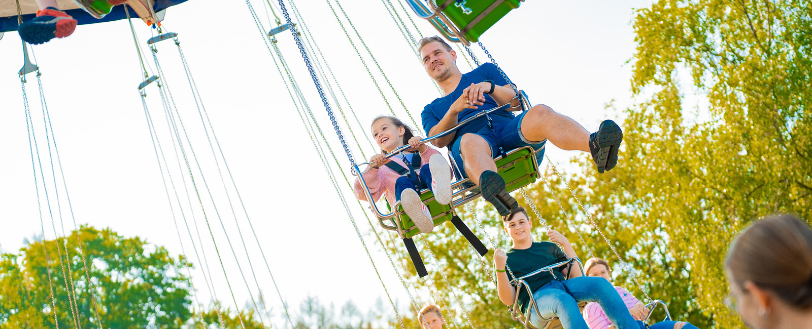 Im Kettenkarussell lassen Papa und Tochter die Füße baumeln.