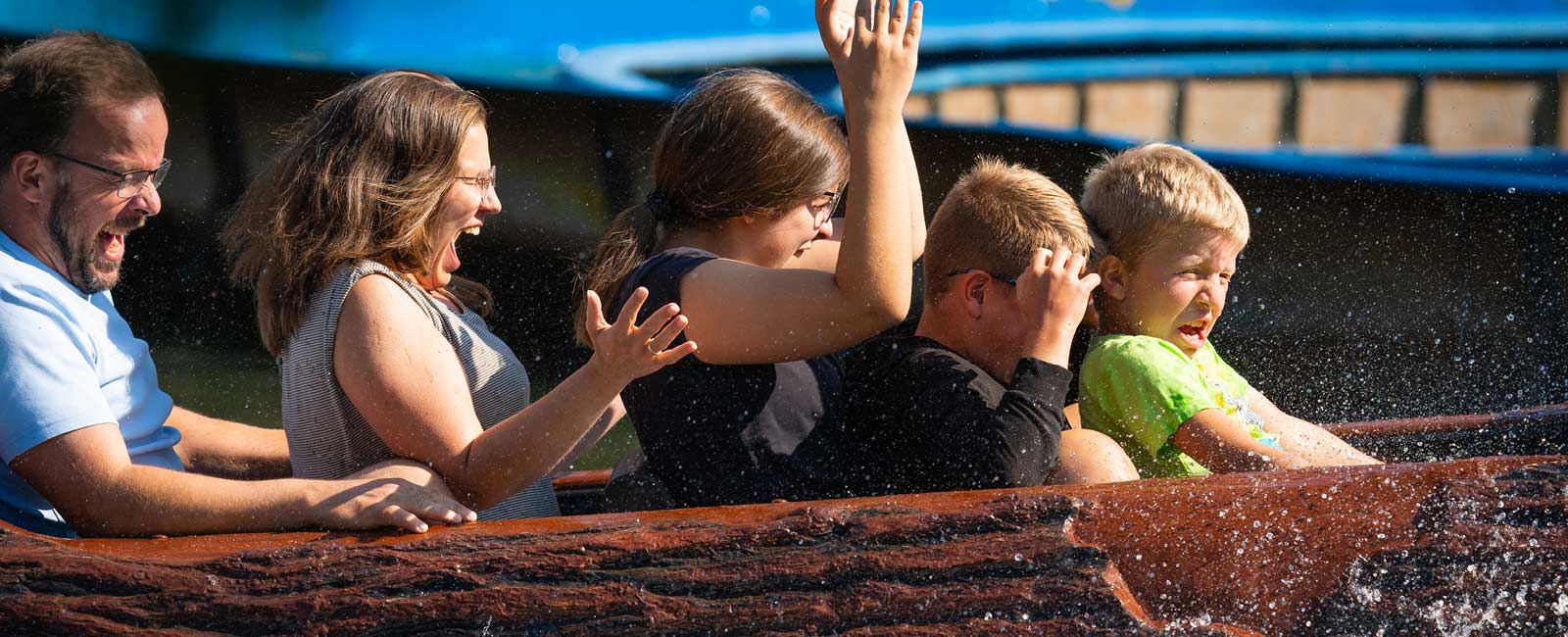 Mama, Papa und die zwei Kinder erfrischen sich in der Wildwasserbahn Wild River.