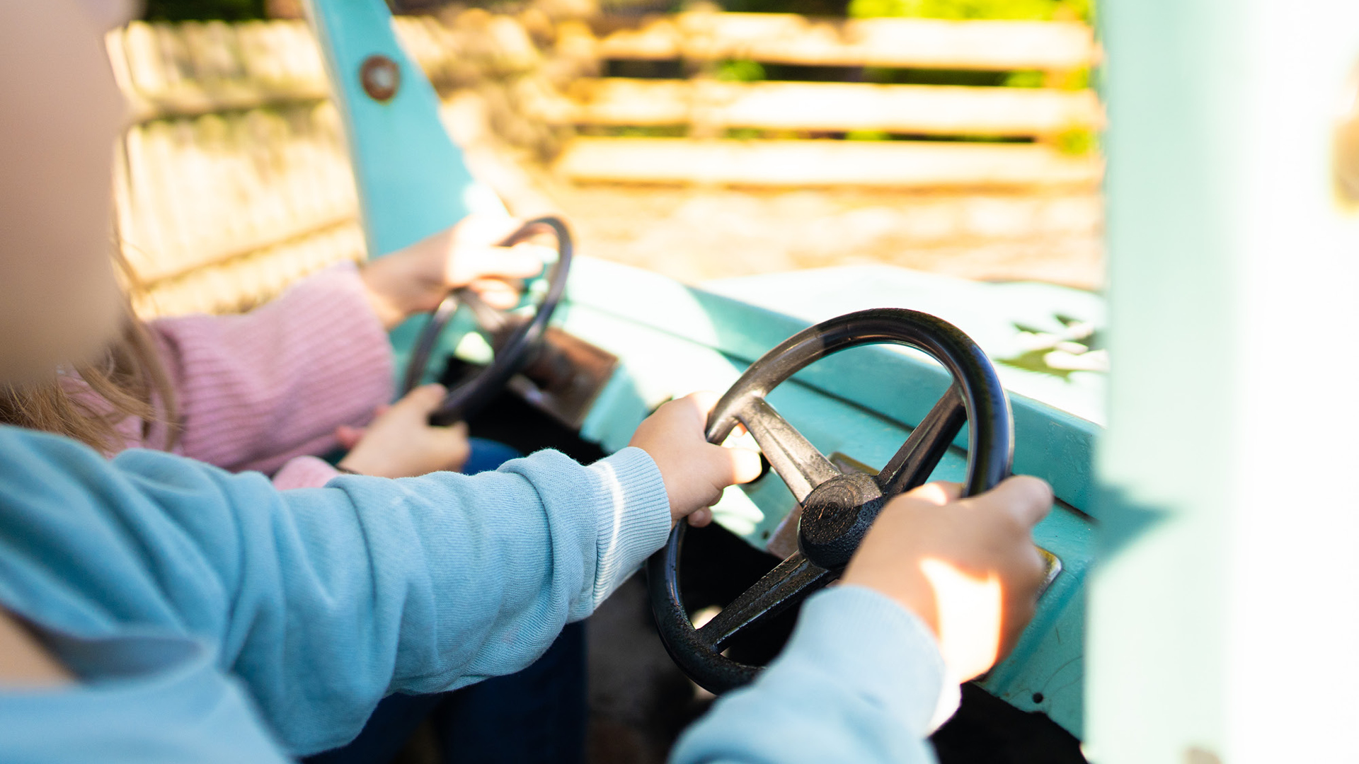 Das Kind fährt im Kids Place mit dem hellblauen Truck durch die Rundstrecke.