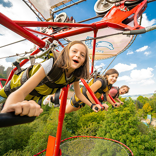 Beim Drachenflug mit dem Wild Eagle kann ein persönliches Video gekauft werden, darüber freut sich die ganze Familie, die gerade über den Freizeitpark fliegt.