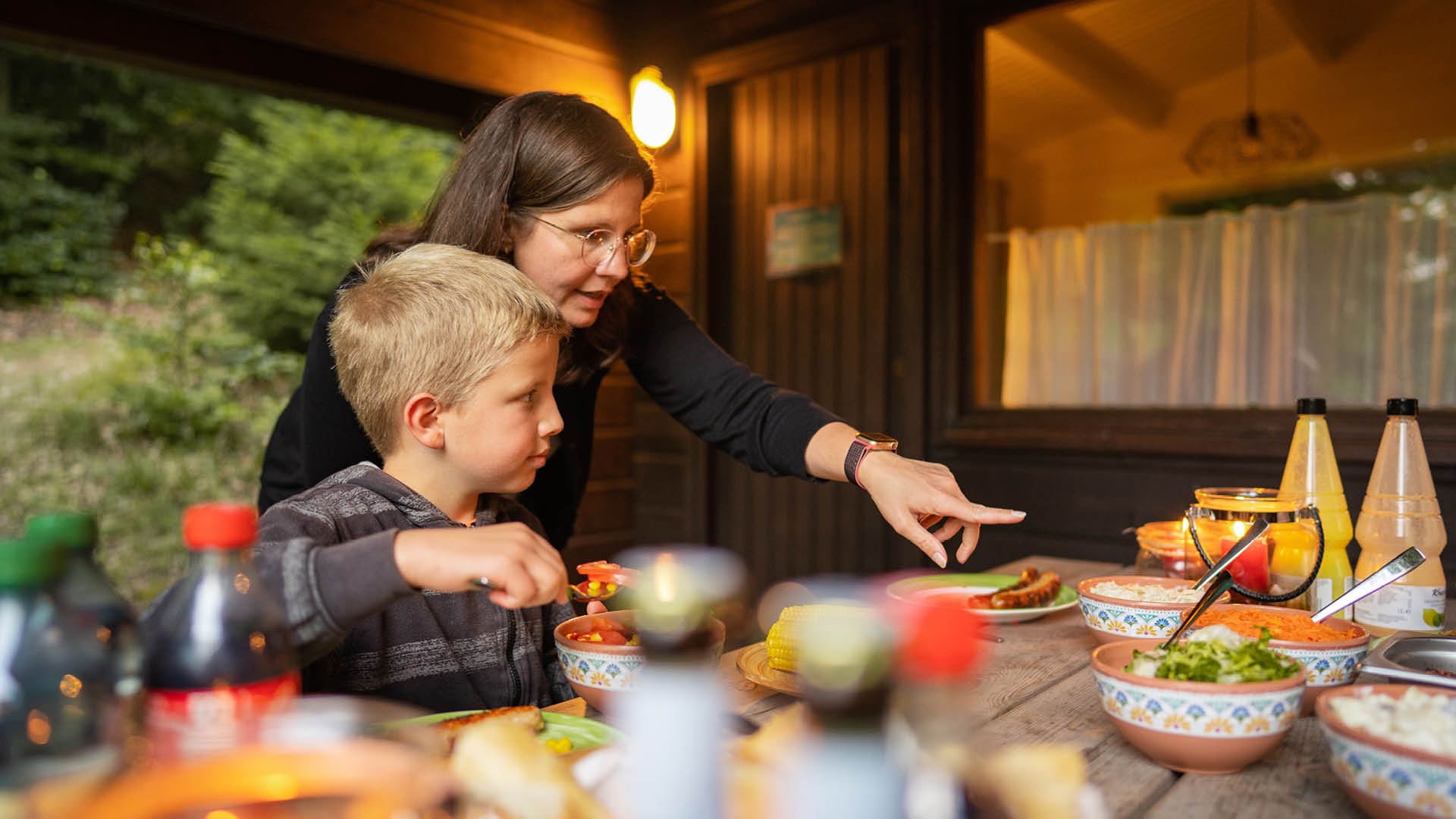 Die Mama zeigt ihrem Sohn die leckeren Sachen zum Abendessen.