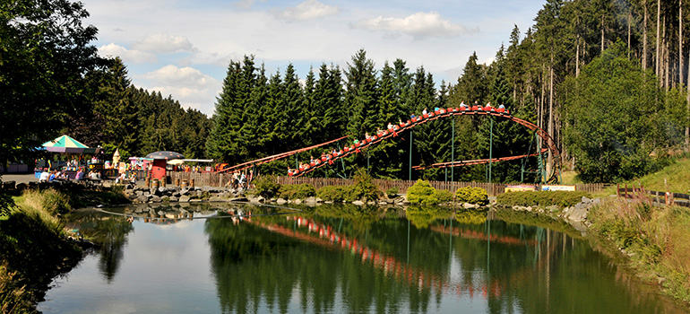 Vor dem See flitzt die Achterbahn, auch Marienkäferbahn genannt durch die Wälder im Sauerland.