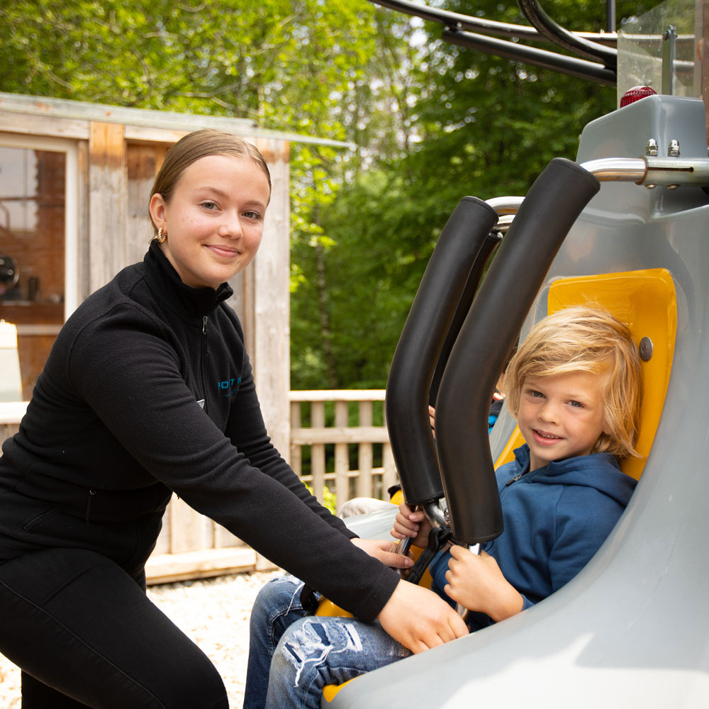 Die nette Mitarbeiterin von FORT FUN hilft dem kleinen Jungen aus dem Fahrgeschäft.